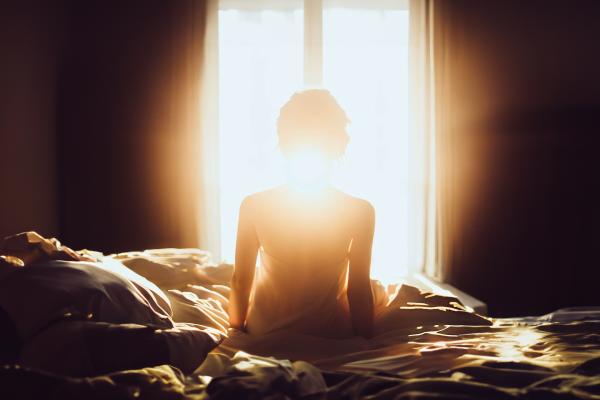 朝日が当たる明るいベッド女性の後ろ姿のシルエット05｜女性の壁紙/画像素材