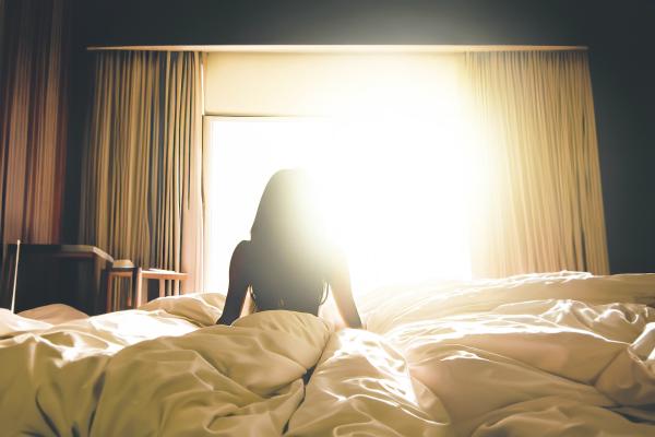 朝日が当たる明るいベッド　女性の後ろ姿のシルエット　07｜女性の壁紙/画像素材