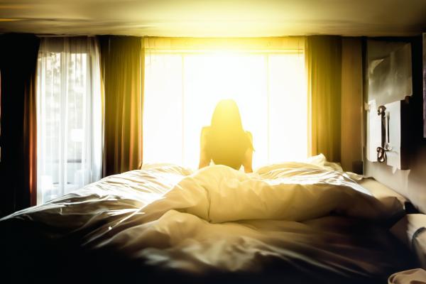 朝日が当たる明るいベッド　女性の後ろ姿のシルエット　08｜女性の壁紙/画像素材